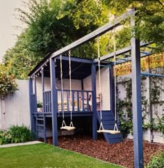 a blue swing set in the middle of a yard