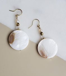 Solazur earrings "Shella" --- Beautiful. Different. Feminine elegance. These earrings will add a pop of style and a boho breeze to your outfit. Seashells are the best summer and beach reminder, and wearing them will make you feel you're on vacation every day :-)  A blend of shell and glass, with an intricate glass shine while the shell's texture reflects its pearly glow from different angles.  The shell coins have a different pattern on each side. They will match beautiful with either a dress or Bohemian Shell Earrings For Gift, Bohemian Shell-shaped Earrings For Gift, Handmade White Mother Of Pearl Earrings, Summer Gift Pearl Earrings With Ear Wire, Elegant Summer Beaded Earrings Gift, Handmade Shell-shaped Pearl Earrings For Gifts, Handmade Shell Pearl Earrings For Gift, Summer Pearl Dangle Earrings, Handmade Pearl Earrings For Summer