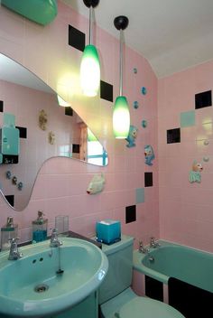 a bathroom with pink walls and black and white tiles on the wall, along with a green bathtub