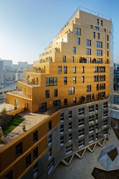 an apartment building with many windows and balconies on the top floor, overlooking a cityscape