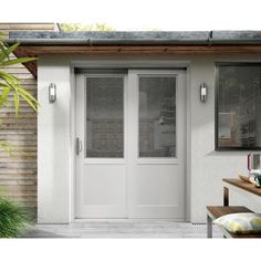 a white front door with two sidelights and blinds on the outside, in front of a house