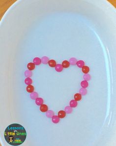 a white plate topped with a heart shaped beaded necklace