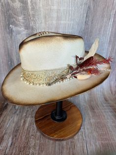 This gorgeous soft brim wool fedora shines with elegance. It's torched to perfection. It has gold accents and a pearl beaded band. It has an adjustable drawstring inner band to fit most size heads.