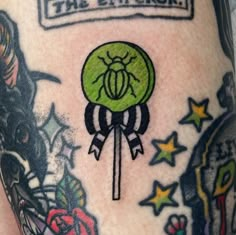 a close up of a person's leg with tattoos on it and an image of a beetle