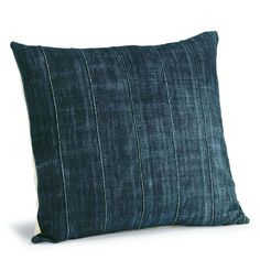 a dark blue pillow with white stripes on the front and back, sitting against a white background