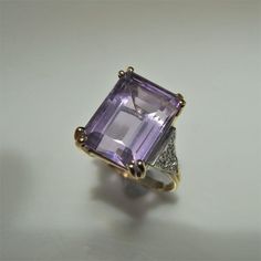 A beautiful natural untreated lilac colored earth mined amethyst and old cut diamond ring in 14K gold, 9.10 carats total weight. The central fine gem quality emerald cut amethyst weighs 9 carats, there is 0.10 carats of I clarity, G color old cut diamonds set into the shoulders. It is sizable. This ring is currently a 5 1/4 US.Inside the shank a 14K metal fineness stamp is present meaning solid 14K gold this confirmed too by testing. This ring rises high off the finger for a classic and luxuriou Art Deco Amethyst Ring In Yellow Gold, Yellow Gold Amethyst Ring In Art Deco Style, Art Deco Yellow Gold Amethyst Ring, Formal Purple Sapphire Ring With Gemstone Accents, Classic Formal Amethyst Ring, Vintage Purple Sapphire Gemstone Ring, Classic Amethyst Rings With Gemstone Accents, Formal Purple Diamond Ring With Gemstone Accents, Classic Amethyst Ring For Collectors