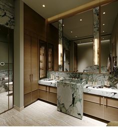 a bathroom with marble counter tops and double sinks in front of large mirrors on the wall