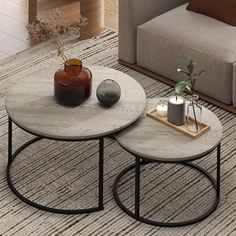 two coffee tables sitting next to each other on top of a carpeted floor in front of a couch