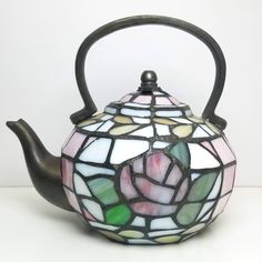 a stained glass tea pot with a black handle