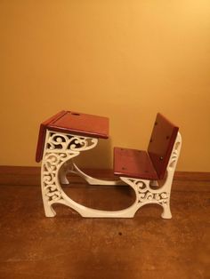 a white and red chair sitting on top of a wooden floor next to a wall