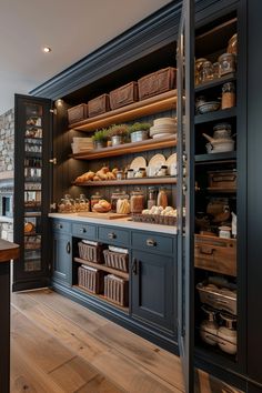 a kitchen with blue cabinets and shelves filled with bread, pastries and other foods