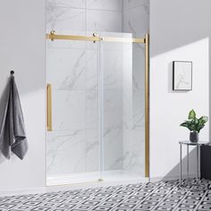 a bathroom with marble tile flooring and gold trimmings on the shower door