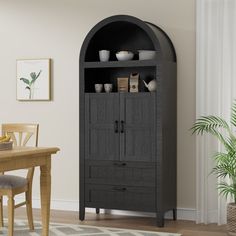 a black bookcase in the corner of a room with a wooden table and chairs