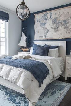 a bedroom with blue walls, white bedding and a large world map on the wall