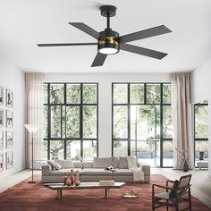 a modern living room with large windows and a ceiling fan in the middle of the room