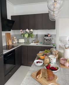 the kitchen counter is covered with fresh fruit and bread