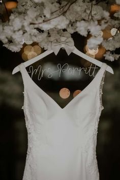 a wedding dress hanging from a tree with the word mr and mrs written on it