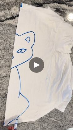 someone holding up a t - shirt with an image of a cat drawn on it