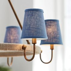 three blue lamps are hanging from a chandelier