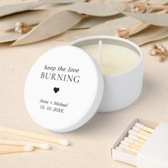 a small white container with matches next to it