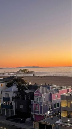 the sun is setting over some colorful houses on the beach in san francisco, california