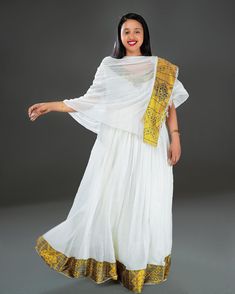 Indulge in the opulence of Ethiopian tradition with our exquisite Habesha dress, adorned in a resplendent golden-yellow hue and adorned with beautiful patterns that tell a story of heritage and elegance. Traditional Gold Gown With Dabka, Gold Gown With Dabka In Traditional Drape Style, Traditional Ceremonies Gold Gown With Dupatta, Traditional Gold Dabka Gown, Gold Gown With Pallu For Traditional Ceremonies, Gold Gown With Dupatta For Traditional Ceremonies, Traditional Gold Gown With Dabka Details, Gold Floor-length Chanderi Kurta, Transitional Season Yellow Anarkali Set Traditional Drape