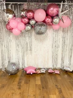 pink and silver balloons are hanging from the ceiling