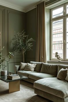 a living room filled with furniture and a large window next to a plant on top of a table