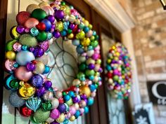 a colorful christmas ornament wreath hanging on a door