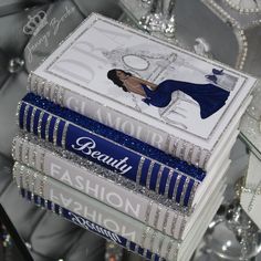 three books stacked on top of each other in front of a crystal table with candles