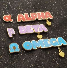 three pin badges that say, alpha and beta to omga with hearts on them