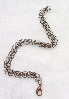 "Large rings of silver tone are \"woven\" together with smaller burnished copper rings to create this interesting chain maille design called Dragon's Tail. Thanks to Tesserex of the Maille Artisans International League for posting the tutorial and inspiration on how to make this pattern. Burnished copper lobster clasp. 8 inches." Silver Chain Jewelry With Copper Material, Metal Link Bracelets With Jump Ring, Nickel Free Copper Bracelet In Silver, Nickel-free Copper Bracelets In Silver, Dragon Tail, Chain Maille, Large Ring, Copper Rings, Infinity Bracelet