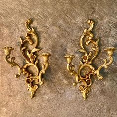 two golden wall sconces on a stone surface