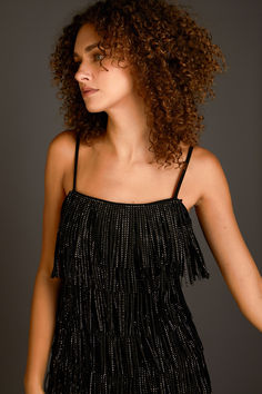 This suede mini dress is perfect for a night out on the town. With its sleeveless design, fringed detail, and embellished accents, this dress is sure to turn heads. Whether you're hitting up a club or going to a fancy dinner, this mini dress is a great choice. You'll look and feel fabulous in this amazing dress. Sleeveless Fringe Mini Dress For Cocktail, Chic Fringe Flapper Dress For Party Season, Glamorous Sleeveless Flapper Dress For Club, Fringed Mini Dress For Night Out, Fringe Mini Dress For Date Night And Party Season, Party Season Fringe Mini Dress For Date Night, Sleeveless Rhinestone Fringe Mini Dress For Club, Club Mini Dress With Fringe For Party Season, Glamorous Sleeveless Mini Dress With Tassels