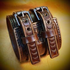 two brown leather bracelets sitting on top of each other