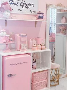 a pink and white kitchen with lots of accessories