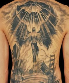 the back of a man's body with tattoos on it and an angel above his head