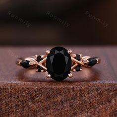 a black diamond ring sitting on top of a wooden box with gold trimmings