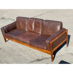 a brown leather couch sitting on top of cement