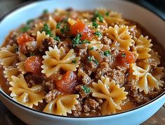 a close up of a bowl of pasta with meat and veggies in it