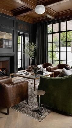 a living room with couches, chairs and a fire place in front of large windows