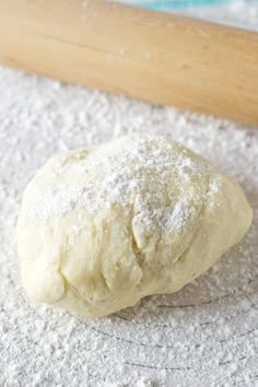 a ball of dough sitting on top of a floured surface next to a rolling pin