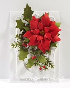 a christmas card with holly and red poinsettis on the front, attached to a white frame