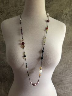 a mannequin torso wearing a necklace with multicolored beads