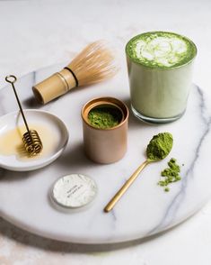 a marble table topped with two cups filled with green powder