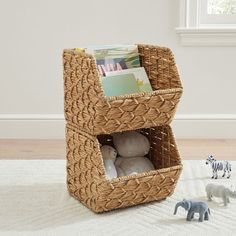 a toy elephant and two stuffed animals in a wicker basket on a white rug