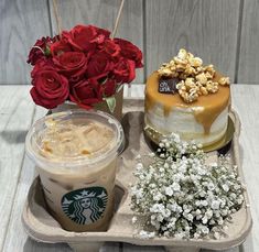 there is a cake, coffee and flowers on the tray next to eachother