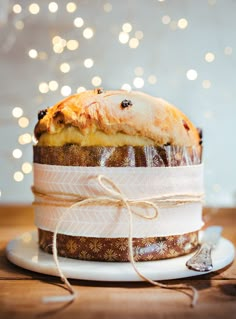 a cake wrapped in paper and tied up on a plate with a ribbon around it