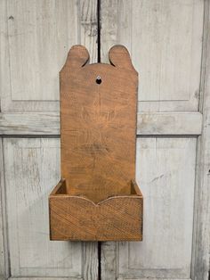 a wooden box with two ears on the top and bottom, attached to a door