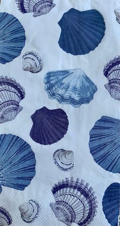 blue seashells on white paper napkins sitting on a table